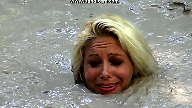 Bizarre Fetish Scene Featuring Busty Blonde Sinks In Lake Of Dirt